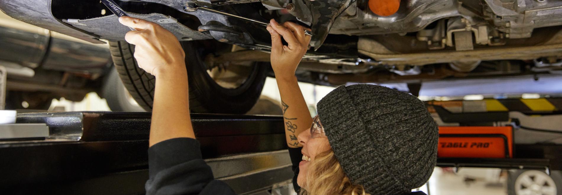 A student works on a car in the Automotive Service Technology Program