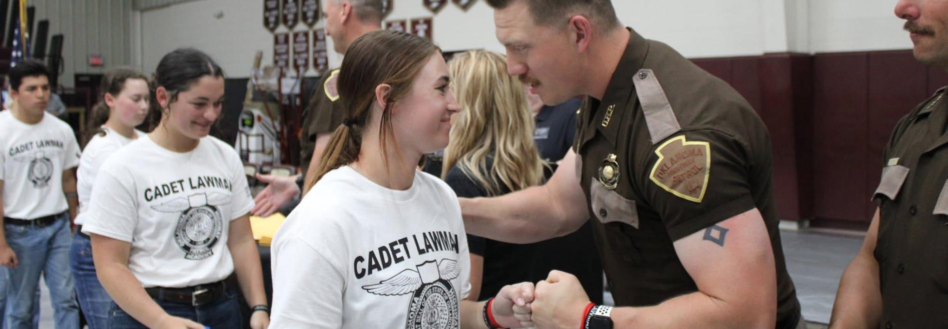 Isabell Strange interacts with a highway patrolman at the Cadet Lawman Academy
