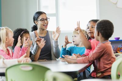 Teacher at a table with students.