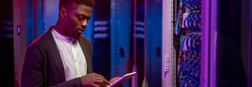 Man using a tablet in a server room