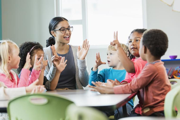 Teacher at a table with students.