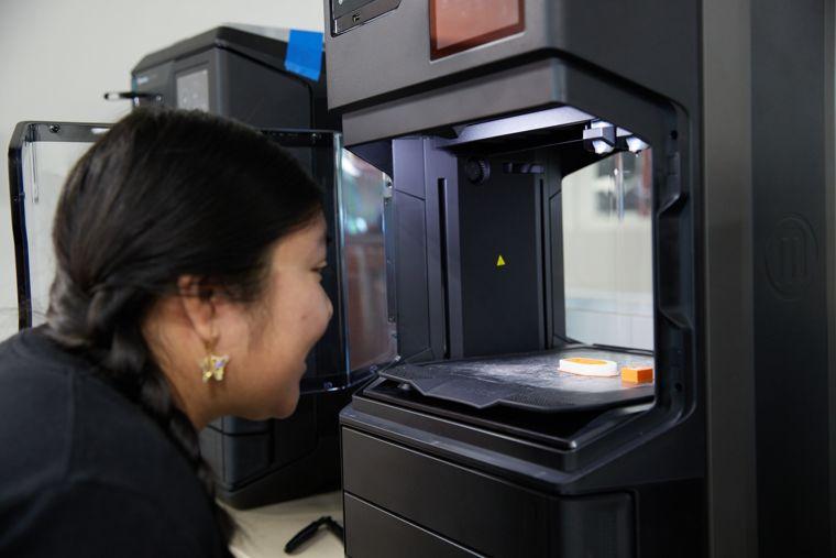 student inspecting a 3d print
