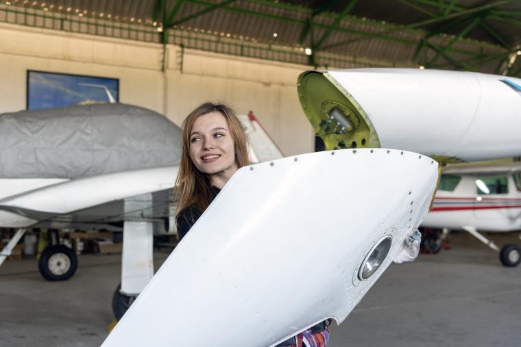 Woman holding aircraft component