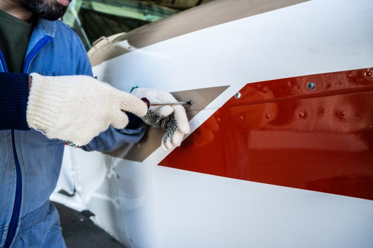 Man checking screws on aircraft part