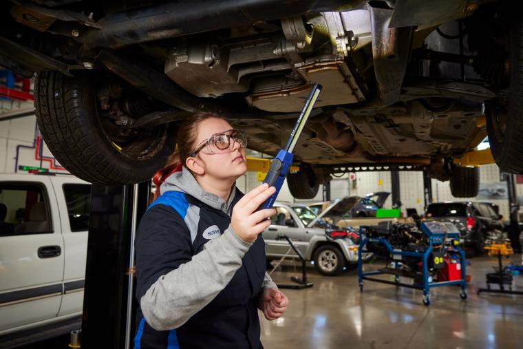 Student working on underside of car