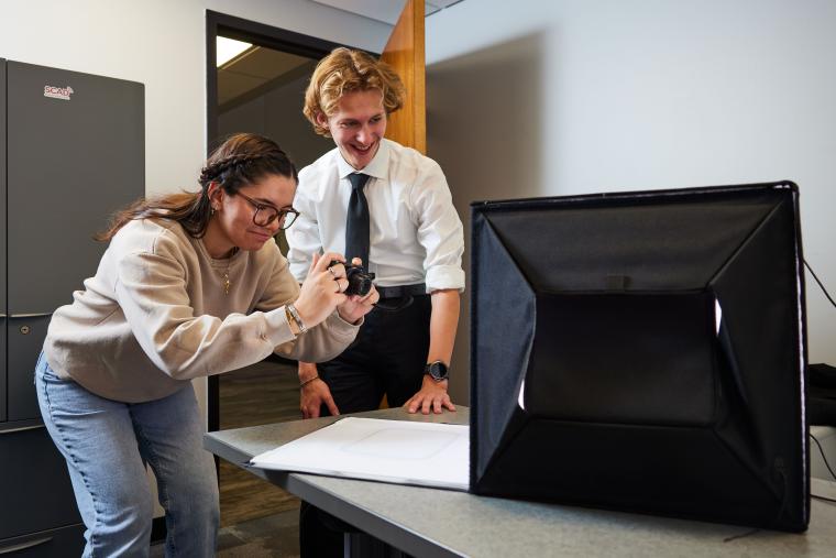 Students taking a picture of an item in a light box
