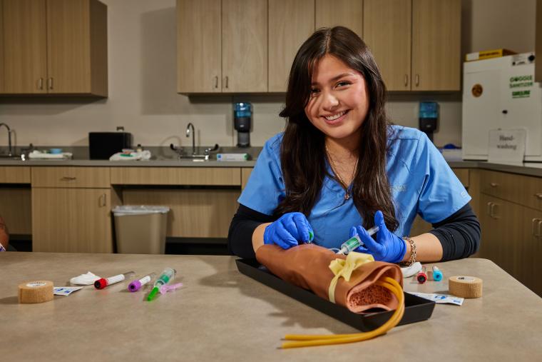 Student practicing administering injection on a model arm