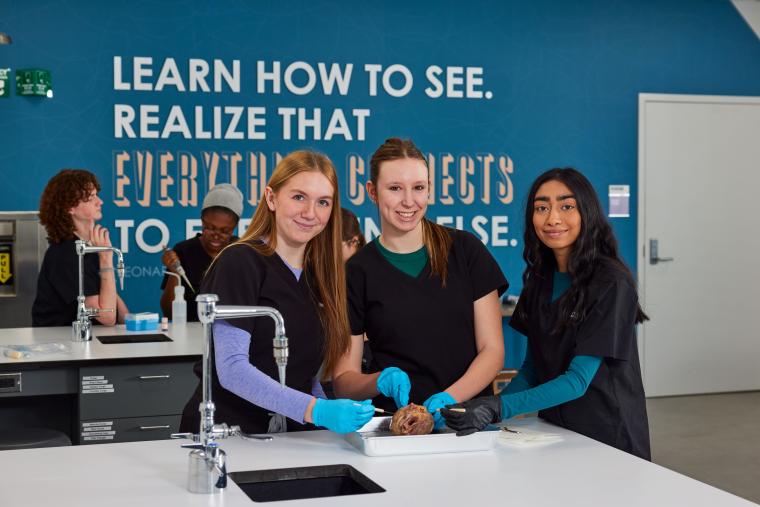 Three students examining an organ