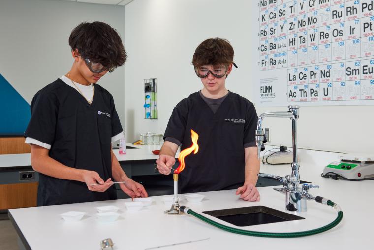 Two students operating a bunsen burner