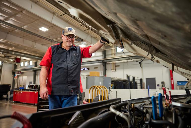 Student opening the hood of a semi truck