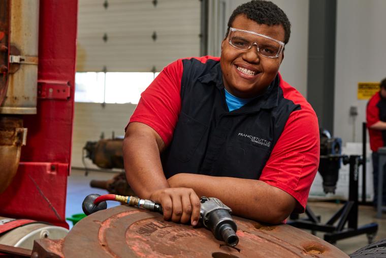 Student working on semi truck trailer hitch 