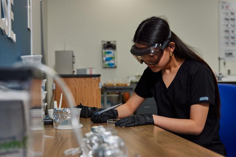 Student inspecting sample in a petri dish