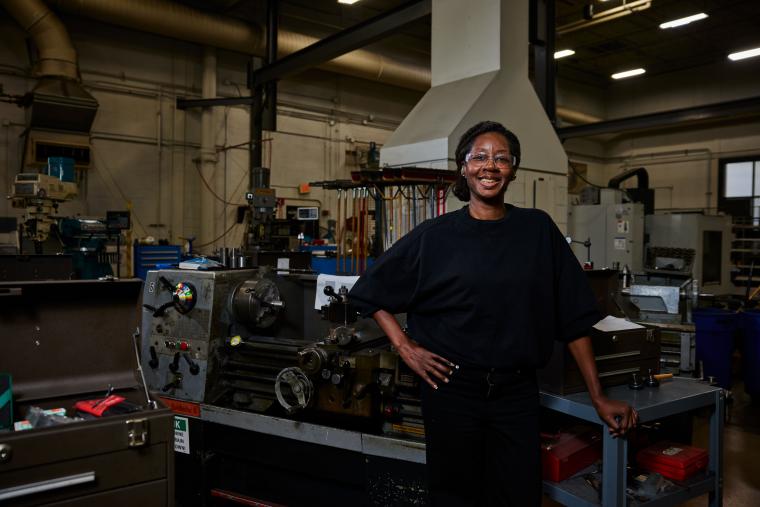 Student standing in front of a lathe