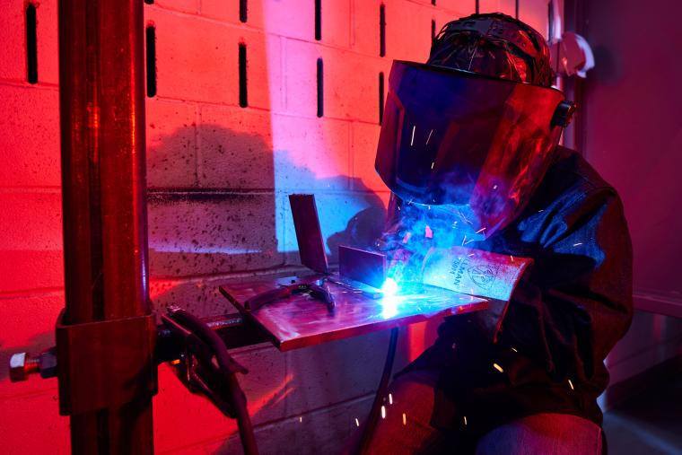 Student welding together two steel sheets