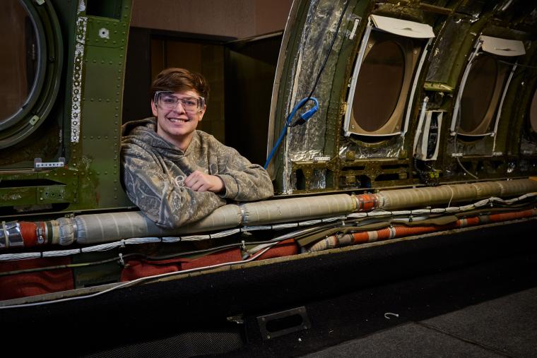 Student leaning into aircraft from outside