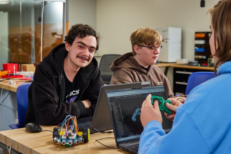 Student designing part for small robot