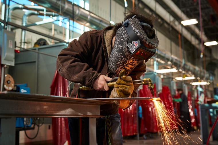 Student cutting piece of steel with a torch