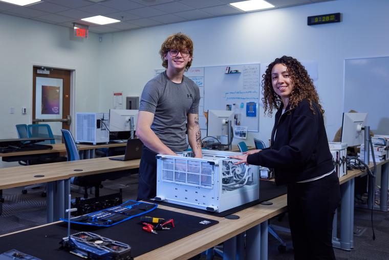 Two students working on the internals of a desktop computer