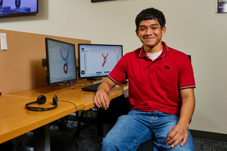 Student modeling a part on a computer