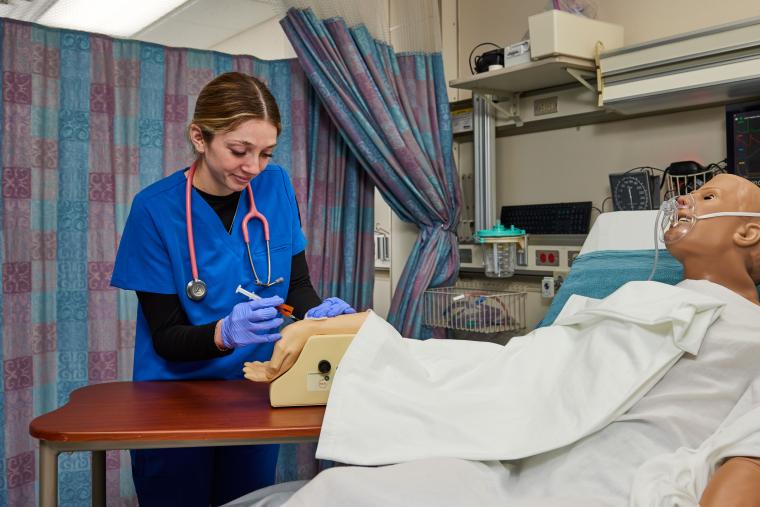 Student practicing administering an injection on a model arm
