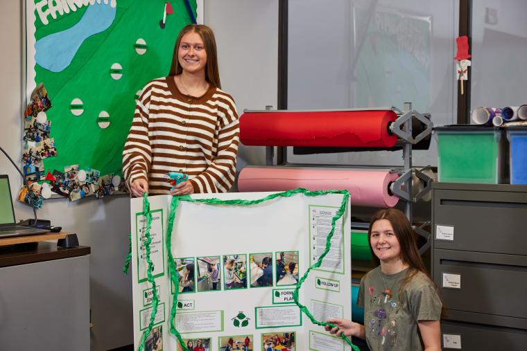 Two students presenting a trifold