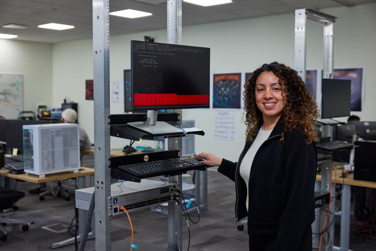 Student operating a terminal mounted to a server rack