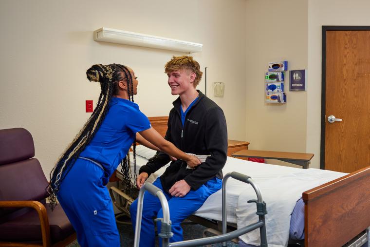 Student practicing helping a patient use a walker