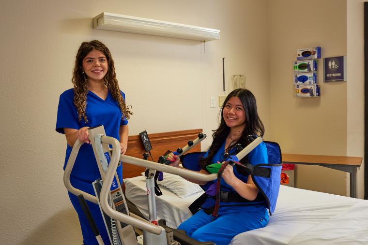 Student practicing assisting patients in a model hospital room