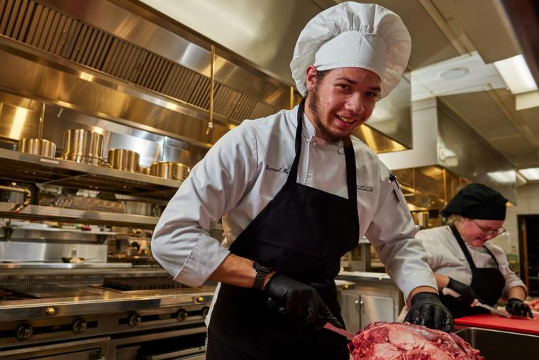 Student carving piece of meat