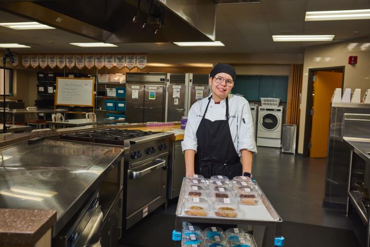 Student pushing a cart with various sweets on it