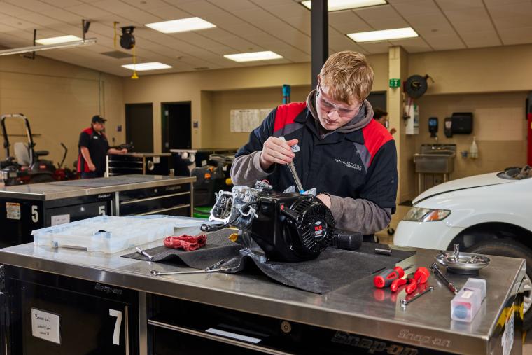 Student working on a small engine