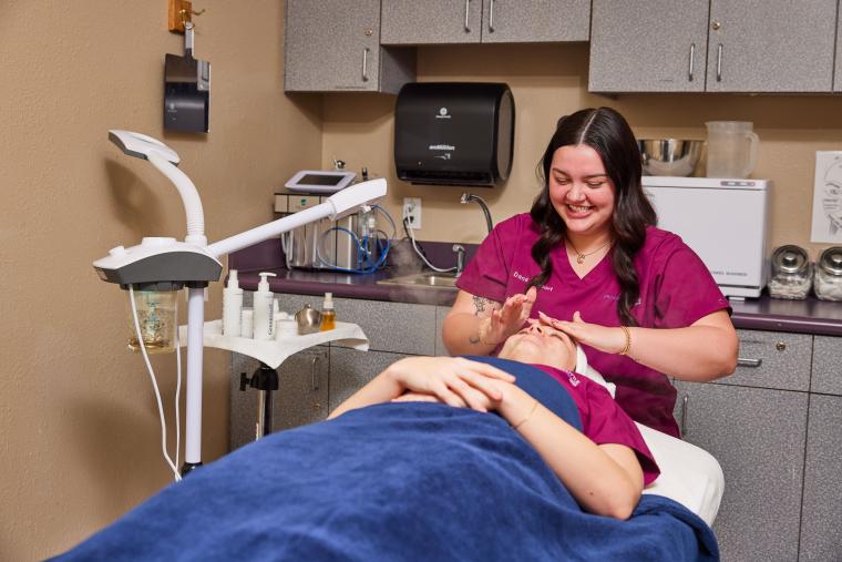 Student applying skin care products to customer's face