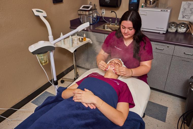 Student applying mist to customer's face