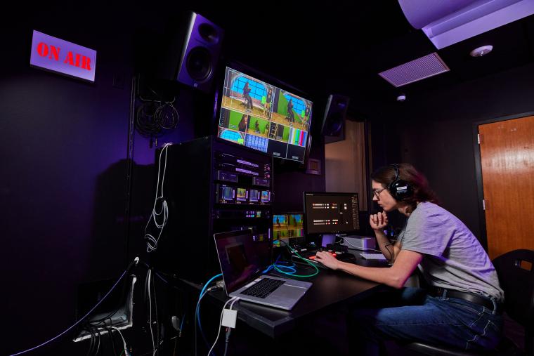 Student overseeing and monitoring several cameras