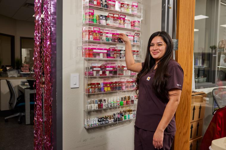 Student looking through a shelf full of nail care products