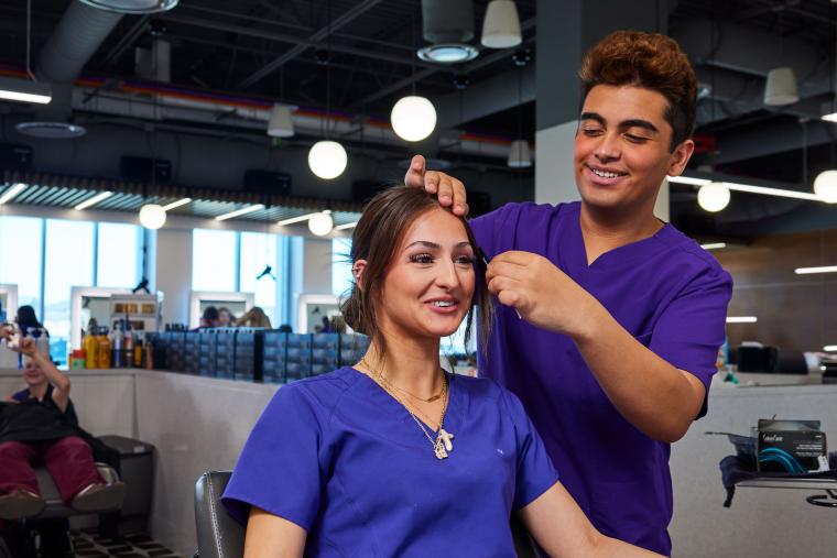 Student practicing combing another student's hair