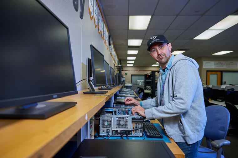Student inspecting the inside of a desktop computer