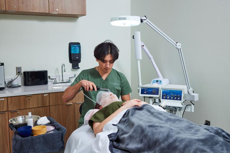 Student applying facemask to customer