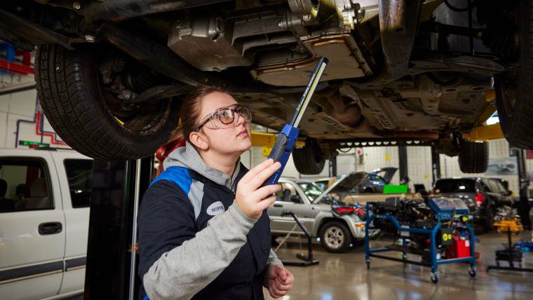 Student working on underside of car
