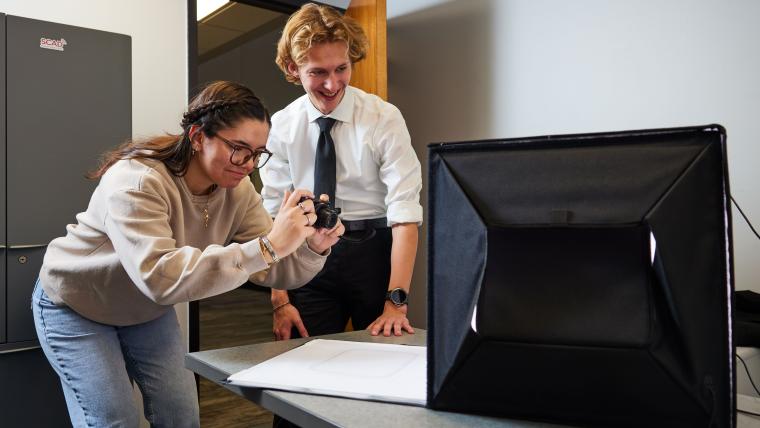 Students taking a picture of an item in a light box