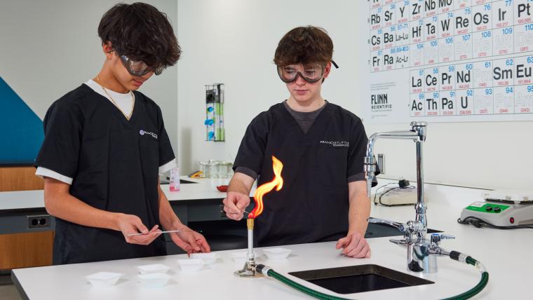 Two students operating a bunsen burner