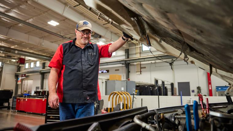Student opening the hood of a semi truck