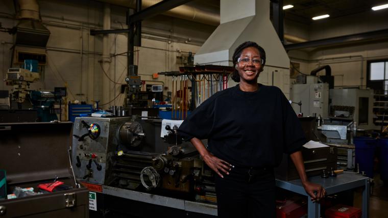 Student standing in front of a lathe