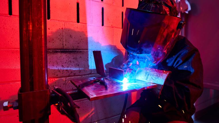 Student welding together two steel sheets