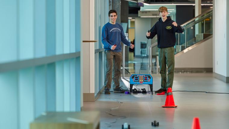 Two students racing small cars