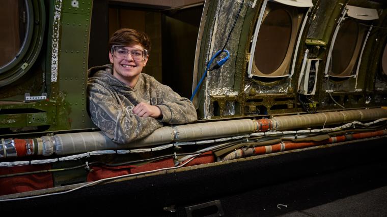Student leaning into aircraft from outside