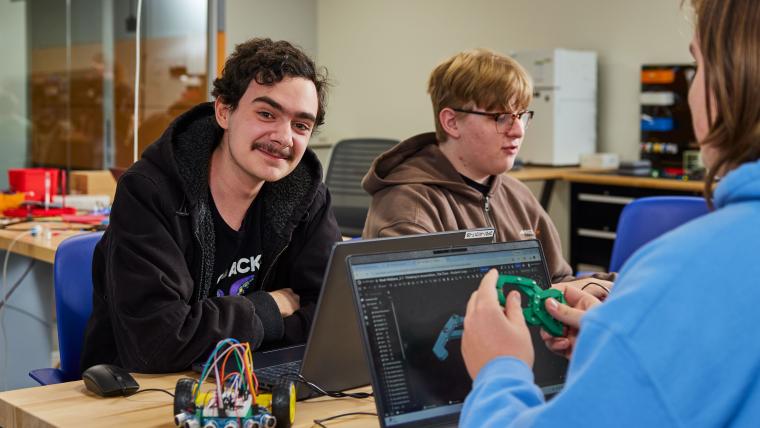 Student designing part for small robot