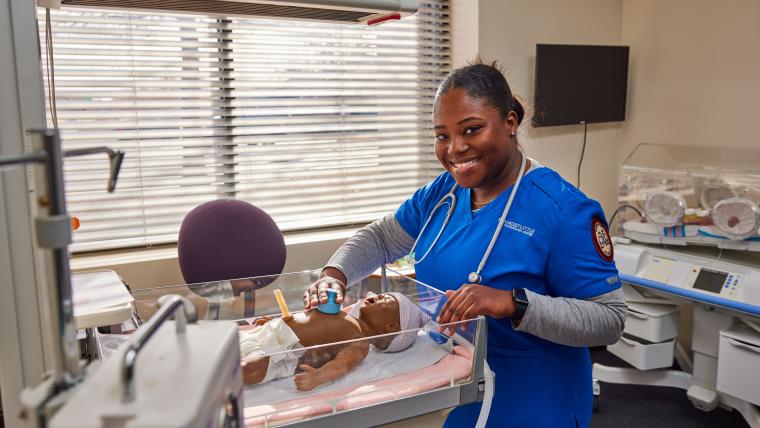 Student practicing checking the breathing of a model infant