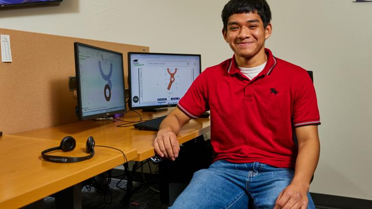 Student modeling a part on a computer