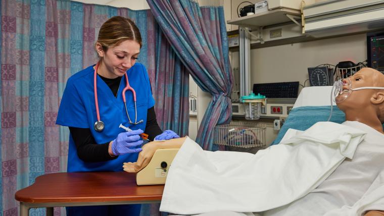 Student practicing administering an injection on a model arm